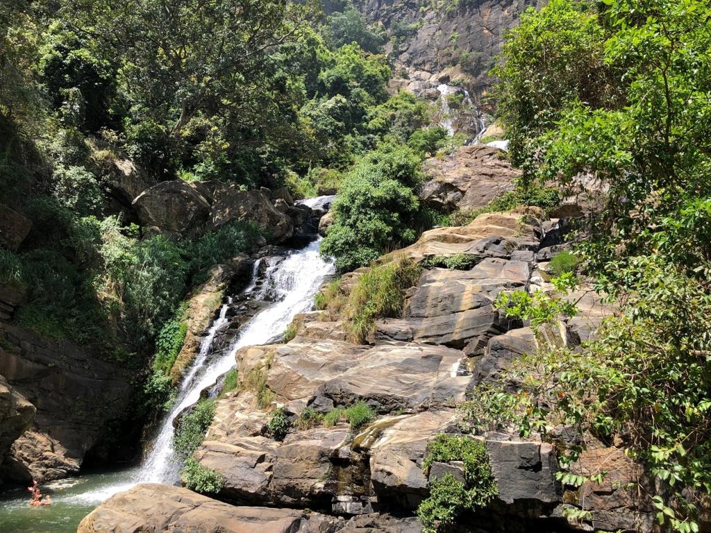 Ravana Falls near Ella, Sri Lanka, cascading over rocks into a pool surrounded by jungle